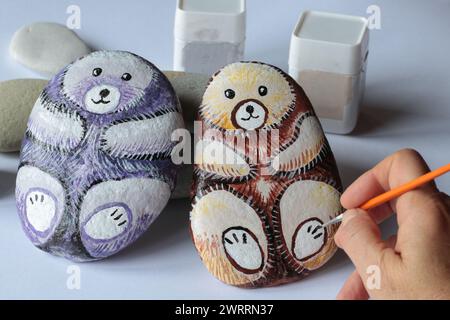 close up of two handmade painted stones on white paper Stock Photo