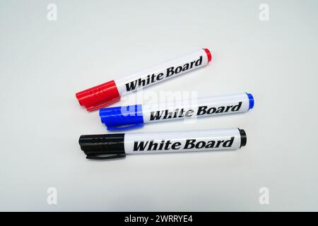 Three color markers, red, black and blue on a white background. Stock Photo
