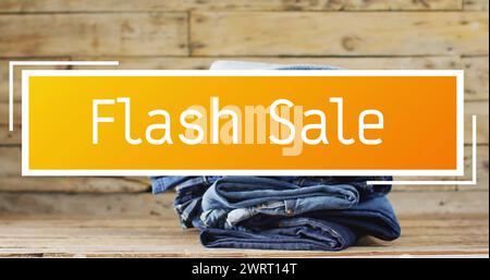 Image of flash sale text over denim trousers on wooden background Stock Photo