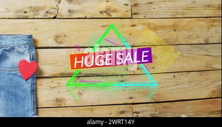 Image of huge sale text over denim trousers on wooden background Stock Photo