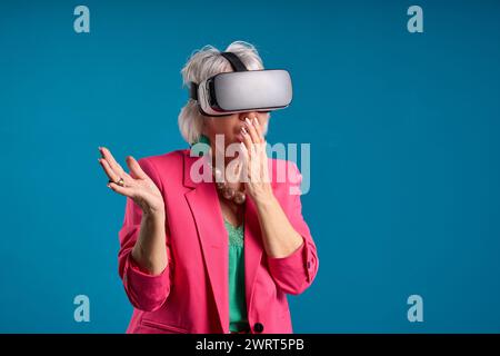 Senior woman can't believe what she sees in virtual reality headset Stock Photo
