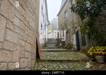 The streets of Monsanto in Portugal on a foggy and rainy day with its cobblestone floor and its small stone houses Stock Photo