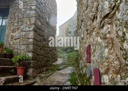 The streets of Monsanto in Portugal on a foggy and rainy day with its cobblestone floor and its small stone houses Stock Photo