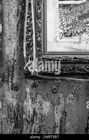 Antique picture frame set against a rusted wall of an old corrugated metal shed in Bridport. Abstract, background of  textures. Grunge. Arty. Stock Photo