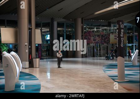 03.08.2023, Singapore, Republic of Singapore, Asia - An air traveller wearing a face mask stands in the newly refurbished departure hall at Changi. Stock Photo