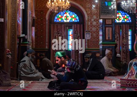 Srinagar, India. 14th Mar, 2024. A Kashmiri Muslim man reads from the ...
