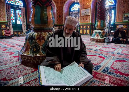 A Kashmiri Muslim man reads from the Islamic holy book Quran inside a ...