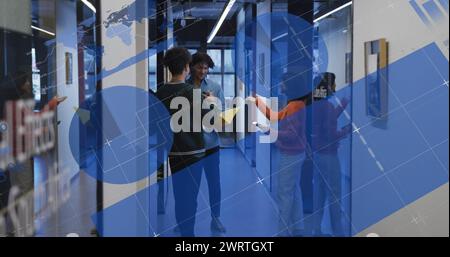 Image of multiple graphs and diverse colleagues discussing documents in office corridor Stock Photo