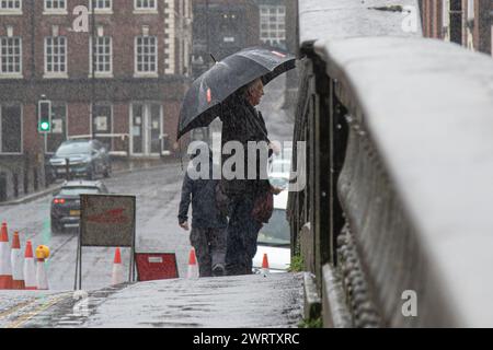 Bewdley, UK. 20th October, 2023. UK weather: Storm Babet is  causing severe flooding across the Midlands. A male pedestrian is standing on the road bridge in the Worcestershire town of Bewdley (now closed to traffic), looking at the high level of the River Severn below, whilst holding a large brolly in heavy rain. Credit: Lee Hudson/Alamy Stock Photo