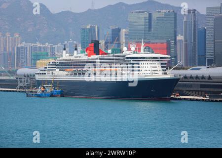 Hong Kong, China. March 14, 2024: Ocean liner Queen Mary 2 docked in Kai Tak for 2 days allowing passengers to discover Greater Bay Area megalopolis. The Cunard Line flagship is currently in Asia as part of its world tour, arriving from Australia/Indonesia, leaving today for Vietnam/Singapore. Following Red Sea tensions & Houthi missile attacks threats on ships transiting the region, the cruise ship, initially scheduled to pass through Suez Canal & Mediterranean, was forced to change its route and will bypass Horn of Africa to reach Southampton on April 28. Credit: Kevin Izorce/Alamy Live News Stock Photo