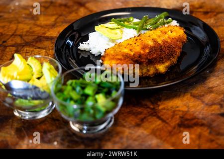 Plate with chicken cutlets, rice, and fruit on a white background Stock Photo