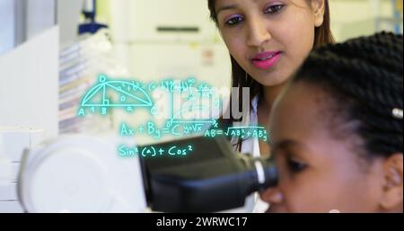 Image of mathematical equations over diverse female doctors using microscope Stock Photo