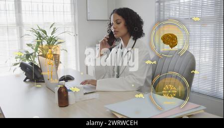 Image of science icons and data processing over biracial female doctor talking on smartphone Stock Photo