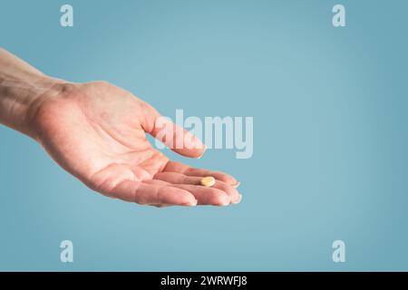 Female hand holding of pill in nurses hand isolated with clipping path. Close up. Stock Photo