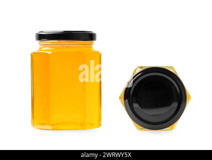 Creative composition of glass jars in the form of honeycombs with honey closed with black lids on a white background close-up. Glass jars with organic Stock Photo
