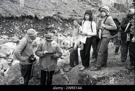 1970s, historical, young people, one studying a map with an instructor, out on an outward bound course, Ambleside, Lake District, Cumbria, England, UK. Outward bound courses help young people build resilience as they take on new challenges and learn leadership and teamwork skills. Stock Photo