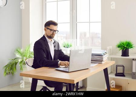 Focused confident businessman working with laptop in office Stock Photo