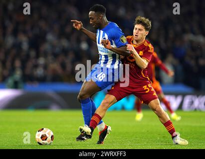 Brighton and Hove Albion's Danny Welbeck (left) and Roma's Tommaso Baldanzi battle for the ball during the UEFA Europa League Round of 16, second leg match at The AMEX, Brighton and Hove. Picture date: Thursday March 14, 2024. Stock Photo