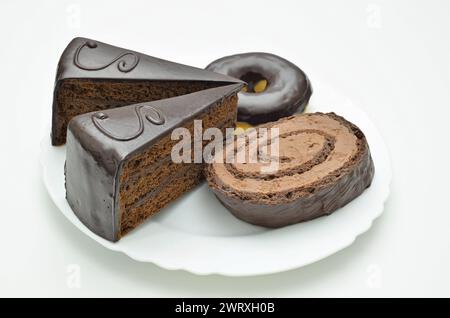 Sacher torte, donut and chocolate tart on white Plate, close up. isolated on white background Stock Photo