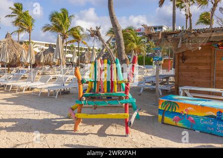 A close-up view of the sandy beach with a large decorative chair made of colorful wooden sticks. Curacao. Willemstad. Stock Photo