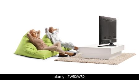 Middle aged woman resting on green bean bag armchair next to a young african american man in front of tv Stock Photo
