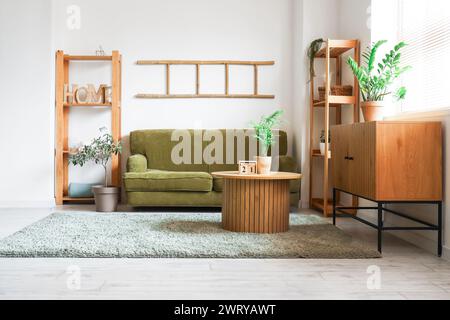 Sofa, wooden table and commode near white wall Stock Photo