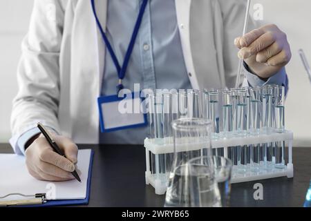 Male chemist with test tubes working in laboratory, closeup Stock Photo