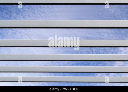 Metal beams against a blue sky background with clouds Stock Photo