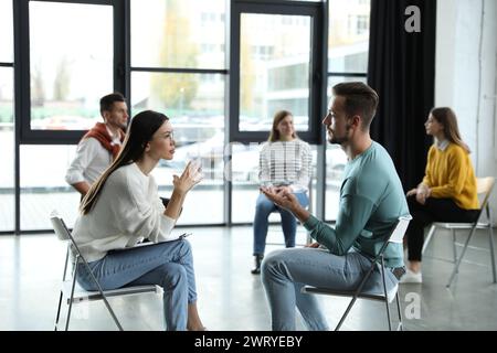 Psychotherapist working with patient in group therapy session indoors Stock Photo