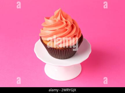 Delicious cupcake with bright cream on pink background Stock Photo