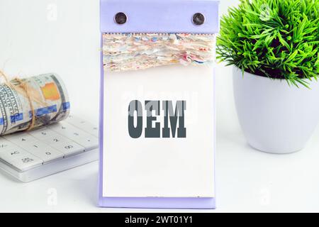 OEM original equipment manufacturer concept. Text on a piece of a desktop calendar with tear-off pages Stock Photo