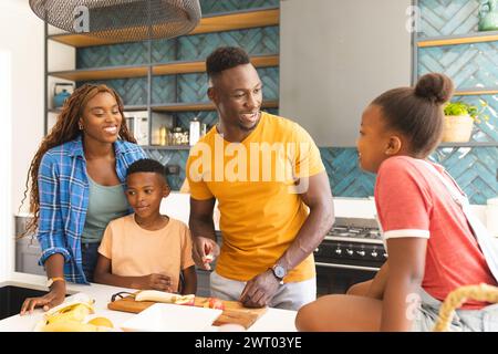 A young African American family enjoys a conversation in the kitchen at home Stock Photo