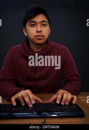 Asian man, face and keyboard for coding, programmer and information technology with video game or software development. Internet, computer programming Stock Photo