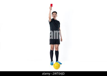 Full length portrait of a football referee giving a red card isolated on white background. Stock Photo