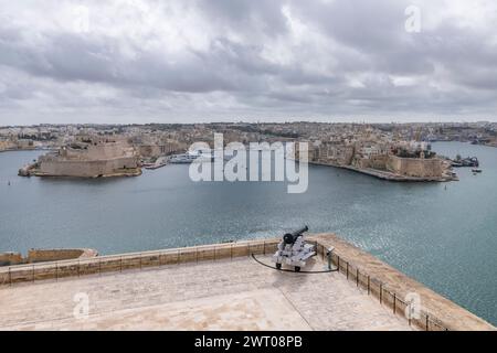 A cannon is aimed at the three cities across the bay in Valletta, Malta Stock Photo