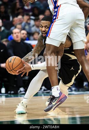 Milwaukee, USA. 14th Mar, 2024. Milwaukee Bucks guard Damian Lillard (L) looks to pass during the NBA regular season game between Philadelphia 76ers and Milwaukee Bucks in Milwaukee, the United States, March 14, 2024. Credit: Joel Lerner/Xinhua/Alamy Live News Stock Photo