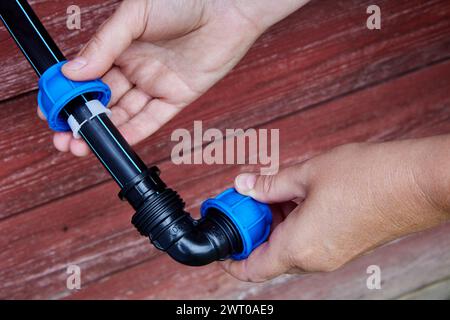Installation of irrigation water supply using an elbow fitting with compression clamp. Stock Photo