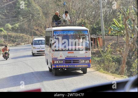 Passengers on the roof of a bus in traffic next to motorcyclists, Pokhara Valley, Pokhara, Nepal Stock Photo