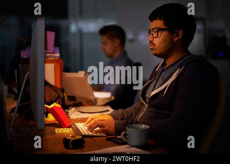 Coding, computer and night with programmer man at desk in office for cyber security development. Fast food, programming and software with confident Stock Photo