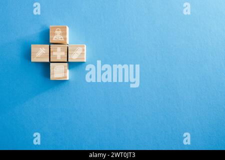 Health background formed with wooden blocks screen printed with medical symbols on a blue background. Top view. Stock Photo