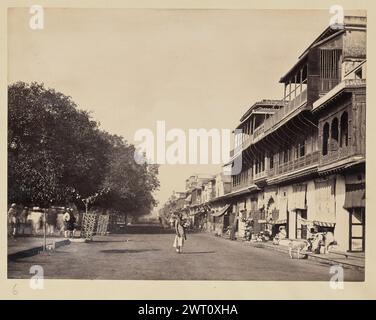 Calcutta street view. Francis Frith & Co., photographer 1850s–1890s View down a street in Calcutta. The street is lined on one side with various shops, and a row of trees on the other. A man stands in the middle of the street looking towards the camera as pedestrians, shopkeepers, and animals move about around him. (Recto, mount) lower left, below print, handwritten in pencil: "6" Stock Photo