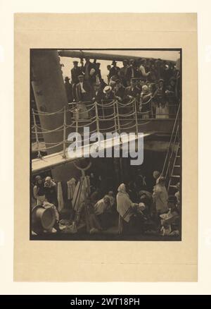 The Steerage. Alfred Stieglitz, photographer (American, 1864 - 1946) 1907 Passengers, primarily women and children, gathered on the steerage of a ship. Additional passengers, the majority of which are men, are crowded on the deck above. Stock Photo