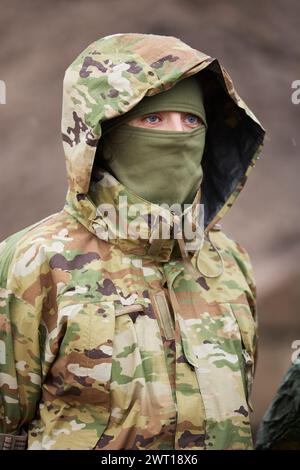 Ukrainian female soldier armed with an assault rifle patrols a combat ...