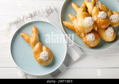 Freshly baked easter bunny made from yeast dough closeup on the plate on the table. Horizontal top view from above Stock Photo