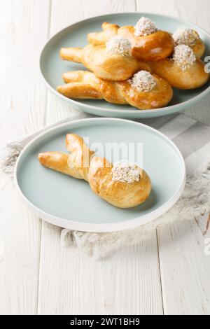 Bunny twist bake decorated with coconut flakes Easter bun closeup on the plate on the table. holiday idea. Vertical Stock Photo
