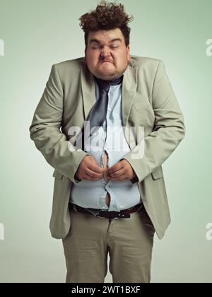 Overweight, portrait and man fitting in shirt, studio and employee with stomach for clothes. Plus size, male person and guy with obesity unhappy with Stock Photo