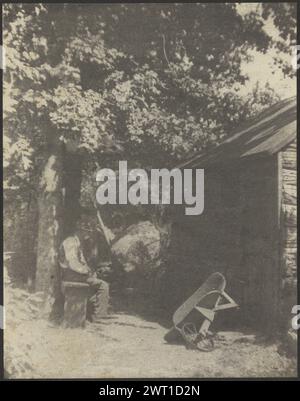 Old Man Sitting Under Tree by Shed, Wheelbarrow Nearby. Doris Ulmann, photographer (American, 1882 - 1934) 1916–1925 An old man is sitting under a tree, on a wooden bench, in a right profile. Part of a shed is visible on the right, with a wheelbarrow in front of it. (Verso, mount) lower left, in green ink: '8 [partially circled]'; Stock Photo