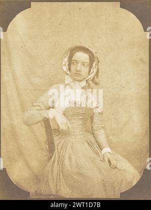 Portrait of a Young Woman in a Checkered Dress. Hippolyte Bayard, photographer (French, 1801 - 1887) about 1845–1847 A portrait of a young woman wearing a checkered dress and bonnet. She is seated and resting one arm on the back of her chair. Her body is turned to look behind her. (Original mount) lower left, pencil: '1860'; Stock Photo