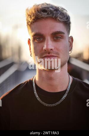 Young handsome man outdoor, with blue eyes and blond hair, looking at camera. Head and shoulder shot Stock Photo