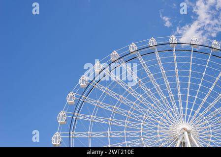 Part of ferris wheel in white color against summer blue sky Stock Photo
